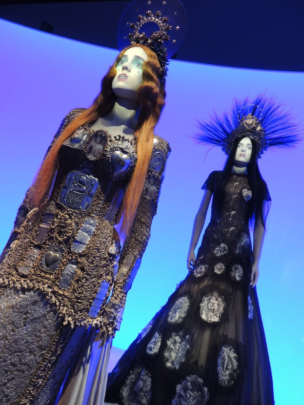 Zwei Schaufensterpuppen in verschiedenen Outfits und mit Kopfbedeckung.