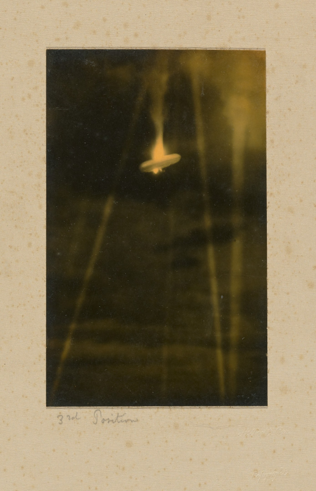 Schwarzes und weißes Foto eines UFO über einem Gewässer mit Text unten.