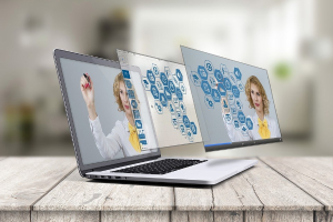 Zwei Laptops auf einem hölzernen Tisch mit unscharfem Hintergrund, auf denen Bilder einer Frau und Text über virtuelle Assistenten zu sehen sind.