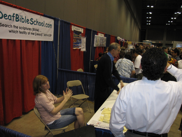 Mehrere Personen in separaten Kabinen mit einem Hintergrund aus verschiedenen gemusterten Vorhängen.