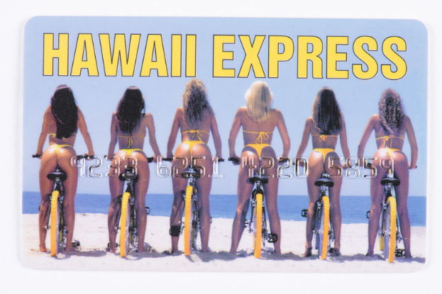 Eine Gruppe von Frauen in buntfarbigen Bikinis fährt Fahrräder auf einem sandigen Strand mit sanften Wellen, unter einem tiefblauen Himmel mit weißen Wolken, mit 'Hawaii Express' quer darüber.