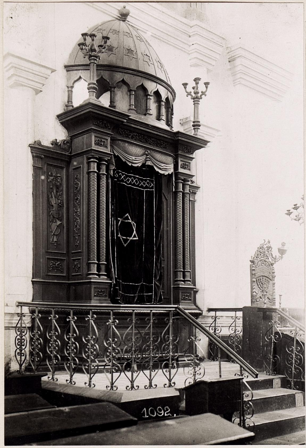 Ein altes Schwarz-Weiß-Foto einer jüdischen Synagoge in New York City, das Treppen, Geländer, Säulen, eine Tür und eine Wand zeigt, mit dem Text 'Jüdische Synagoge in New York City' unten.