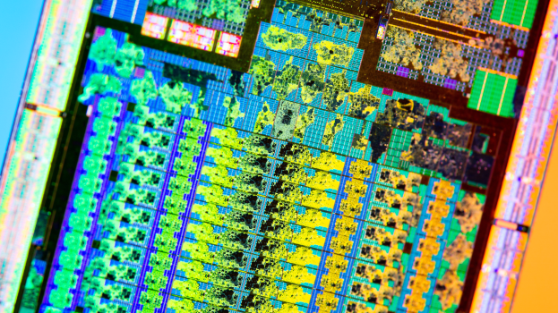 Ein Nahaufnahme eines farbenfrohen Computerchips auf einem blauen Hintergrund, der verschiedene Farben wie Blau, Grün, Gelb, Rot und Orange zeigt.