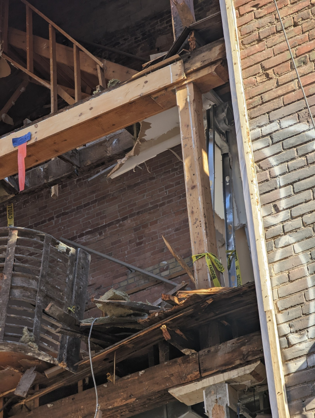Ein teilweise abgerissenes Gebäude mit verstreuten Holzplanken und Trömmern, zerbrochene Fenster und Türen im Anschluss an die Abrissarbeiten.