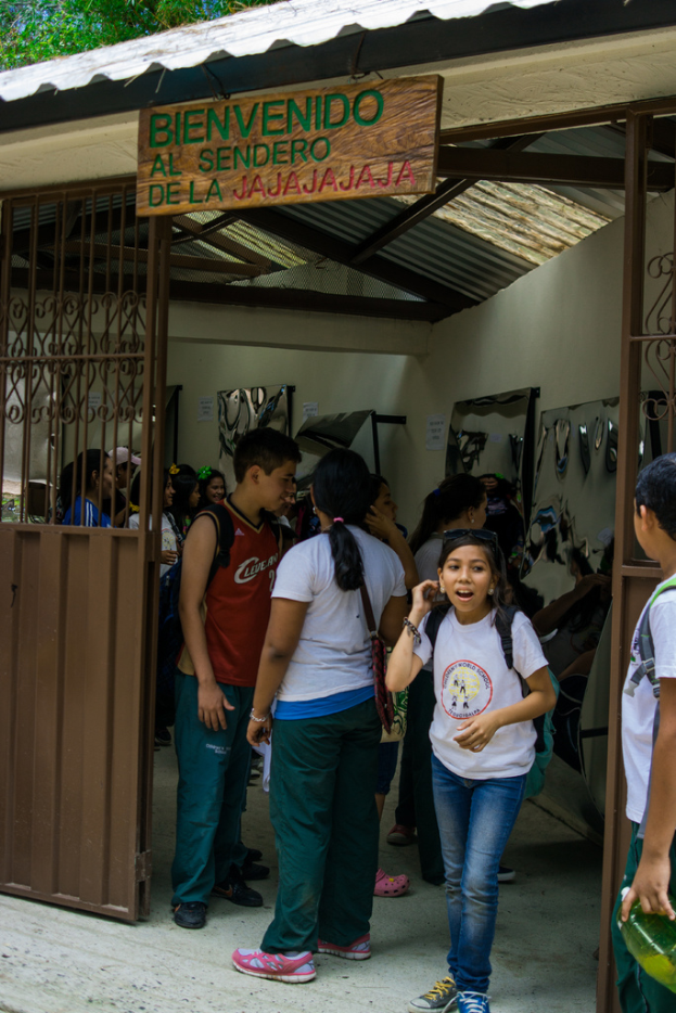 Ein Laden mit einer Eisentafeläußen und einem Schild mit Text oben drauf, mit Menschen drinnen.
