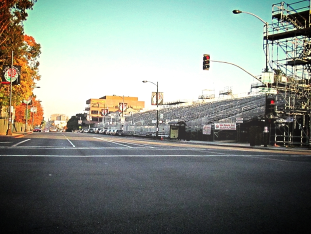 Eine Straße mit einer Verkehrsampelstange und -ausrüstung auf der rechten Seite, Warnschilder und mehrere Fahrzeuge auf der linken Seite und Bäume im Hintergrund.