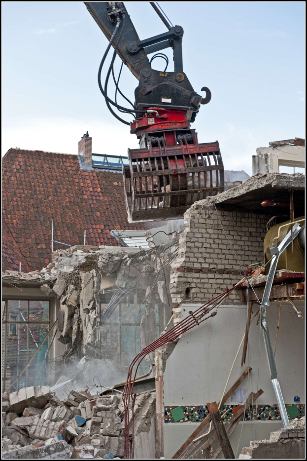Bagger beim Abriss eines Gebäudes mit einem Kran im Vordergrund und Himmel im Hintergrund, Text unten.