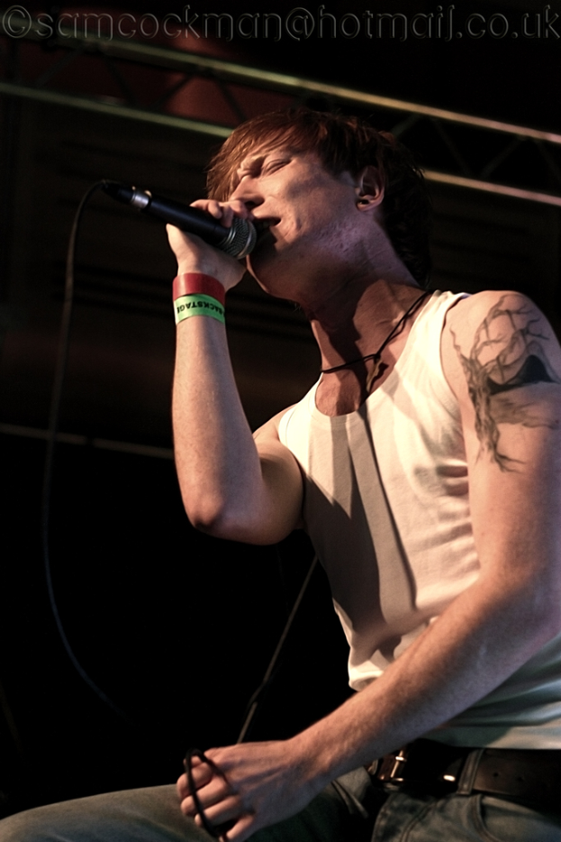 Ein Mann mit einem Mikrofon und singend.