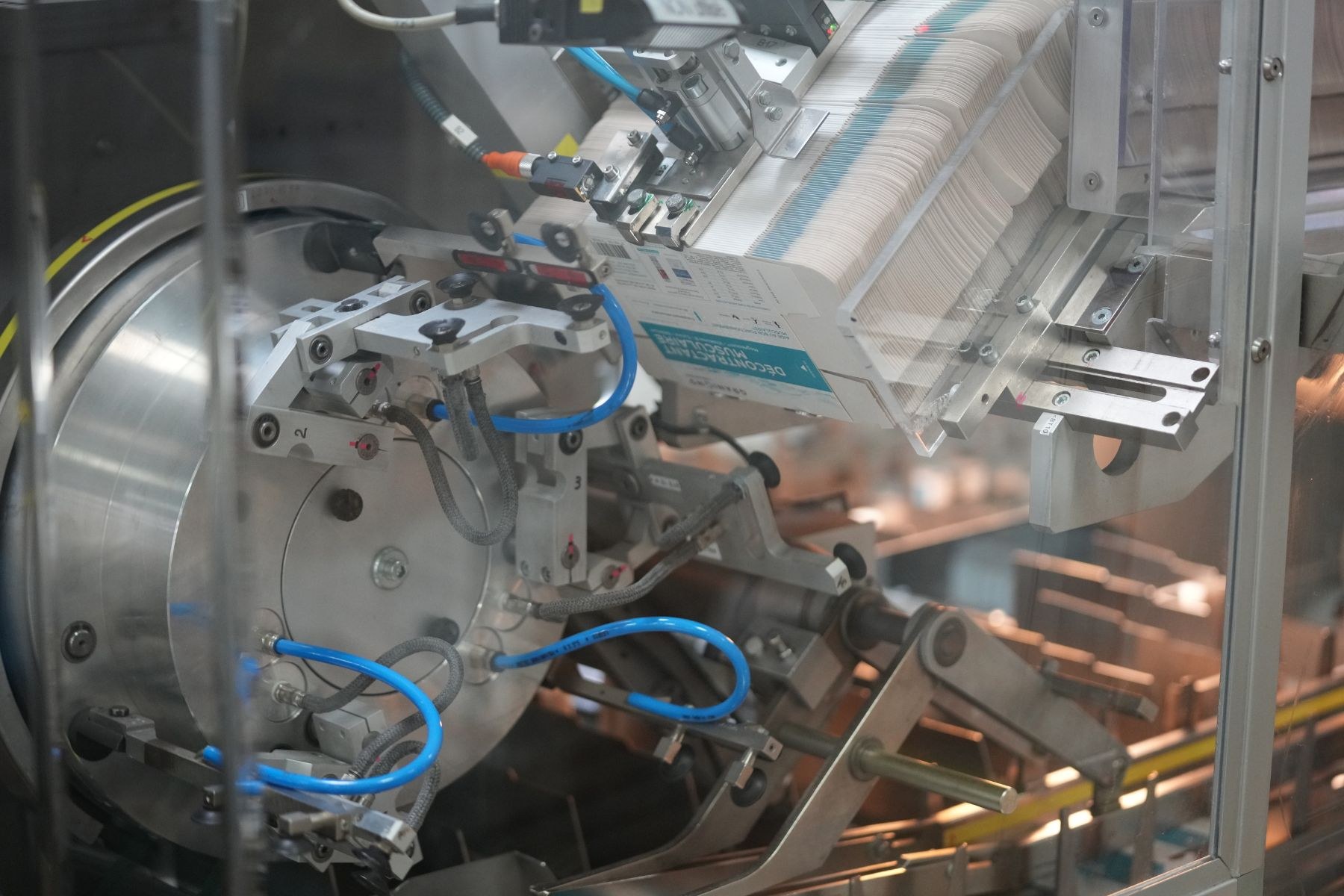 Automatisiertes Verpackungssystem auf einem Fabriktisch mit unscharfen Hintergrundobjekten.