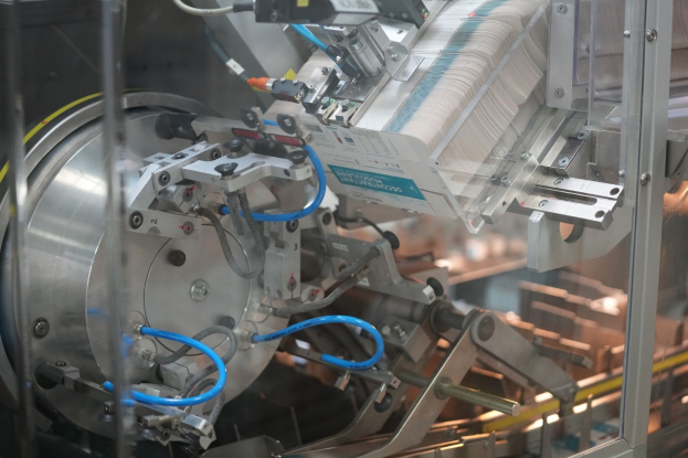 Automatisiertes Verpackungssystem auf einem Fabriktisch mit unscharfen Hintergrundobjekten.