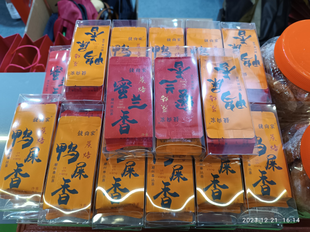 Ein Tisch voller verschiedener verpackter Lebensmittel und Gegenstände, mit einer Person im Hintergrund während eines chinesischen Neujahrsfestes.