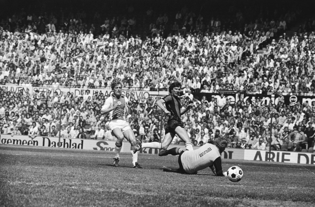 Schwarzes und weißes Foto von Männern, die auf einem Feld Fussball spielen, mit Zuschauern im Hintergrund und einer Bundesliga 1978-79 Ajax 1-1 Hannover 96-Tafel.