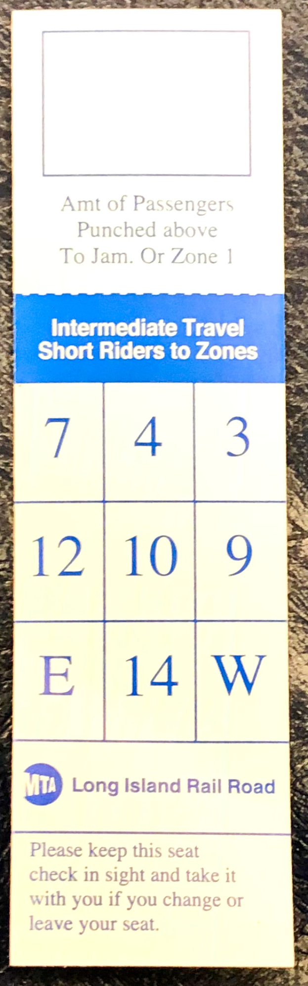 Ein blau-weißer Fahrschein mit bedrucktem Text und Zahlen liegt auf einem Tisch.