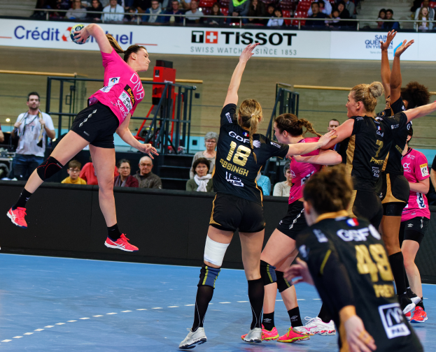 Frauen spielen Handball auf einem Feld mit einem Ball in der Luft, Zuschauer im Hintergrund und ein Schild mit der Aufschrift "Futsal-Weltmeisterschaft 2019 - Bordeaux gegen Paris".