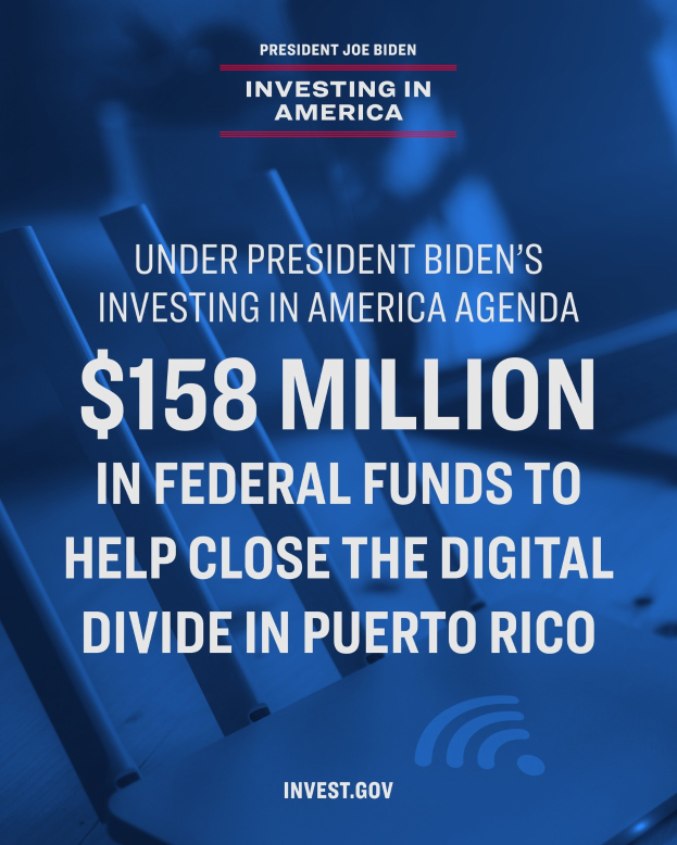 Plakat mit der Aufschrift "Im Rahmen des America Agenda-Programms von Präsident Biden: 158 Millionen Bundesmittel, um die digitale Kluft in Puerto Rico zu schließen" mit einem Laptop, Papieren und einem Kaffeebecher auf einem Tisch davor.