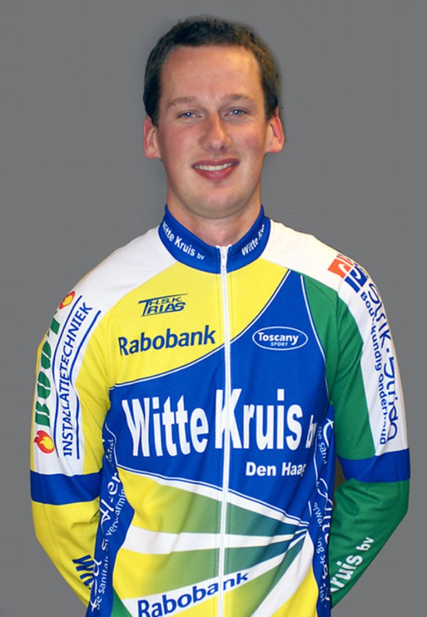 Ein männlicher Athlet posiert für ein Foto mit sichtbaren Sponsorenlogos auf seinem Trikot.