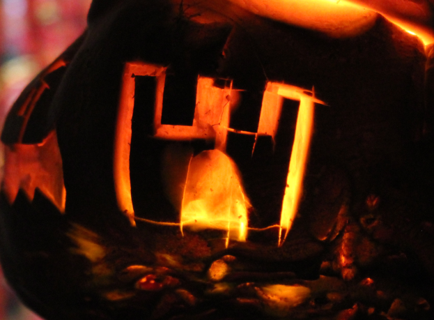 Eine Laterne mit dem Wort "Halloween" darin, von innen beleuchtet, mit einem unscharfen Hintergrund.